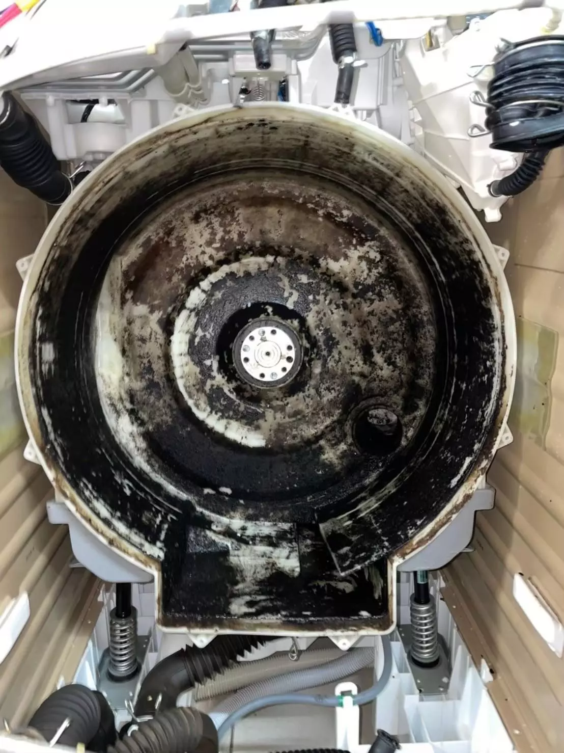 近距離觀察洗衣槽內部，髒污附著在滾筒和內槽縫隙中，這些霉斑與污垢若不清理，會影響洗衣效率並滋生細菌。